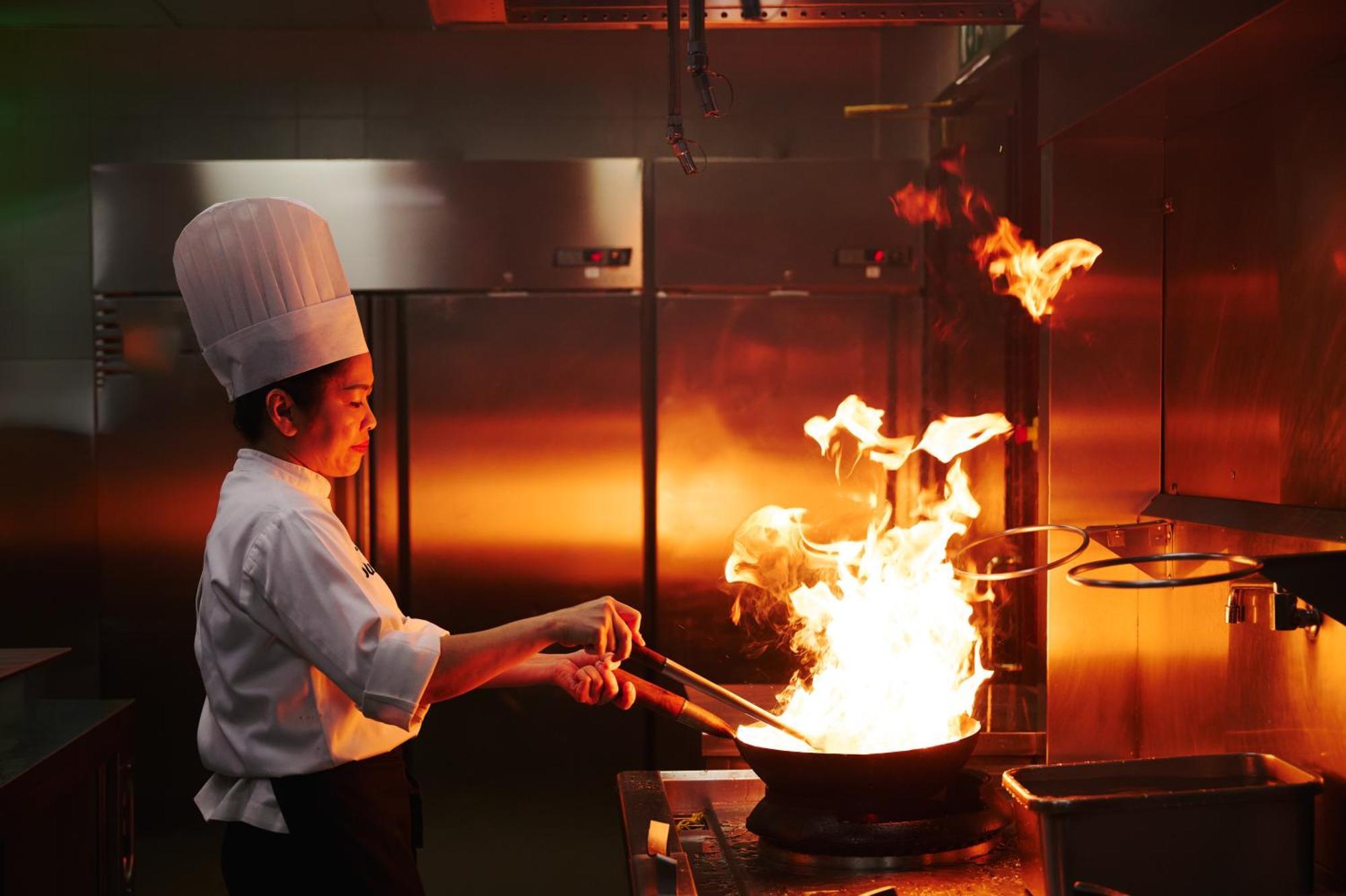Dusit Doha Hotel Экстерьер фото A chef cooking with a wok